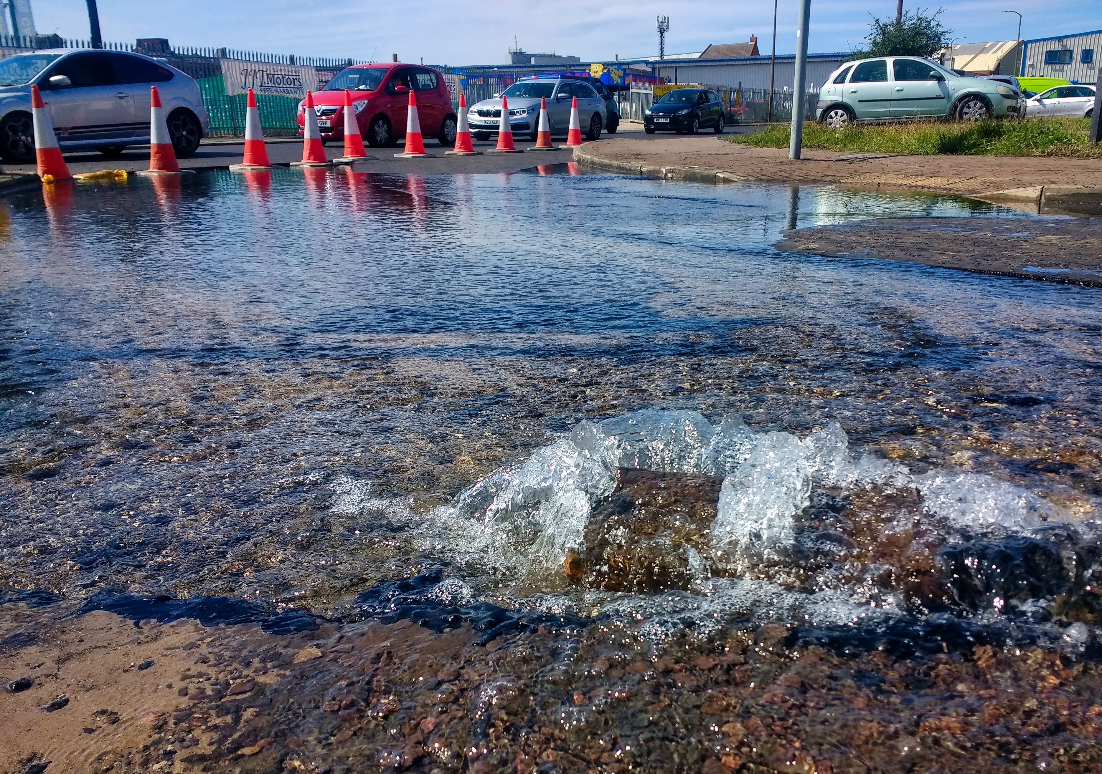 A burst pipe overspills into a road