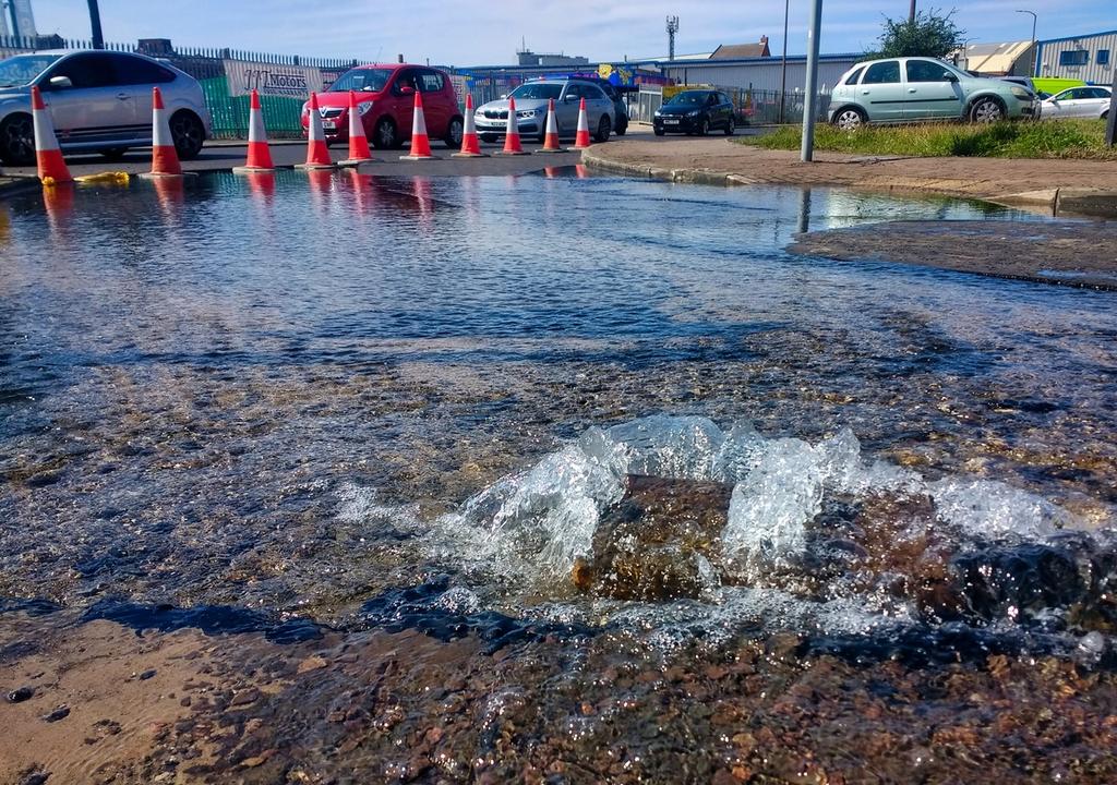 A burst pipe overspills into a road