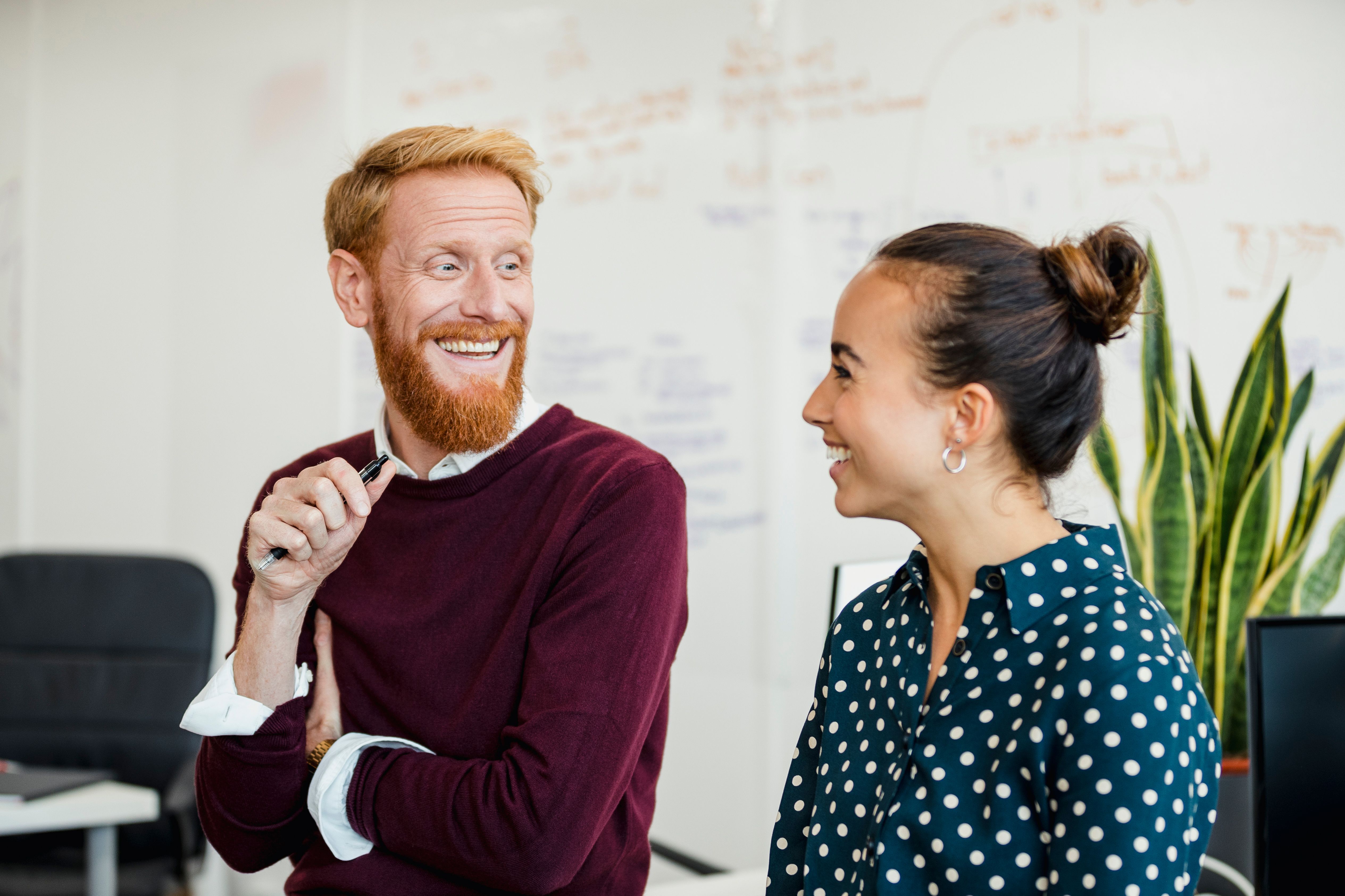 Two staff members chat in a workplace