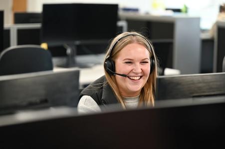 Customer service agent laughing into her headset 