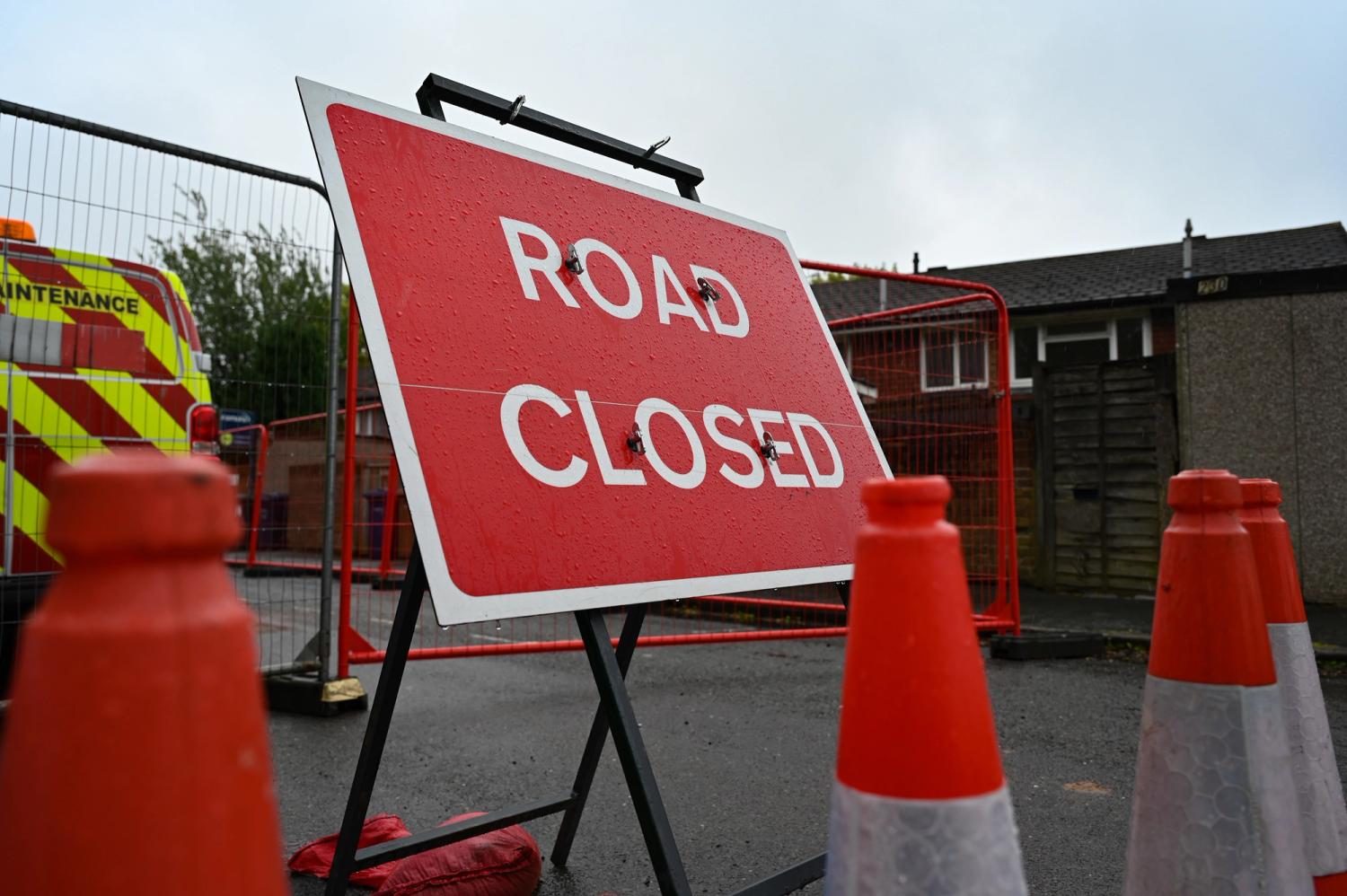 A road closed sign is shown in front of fencing