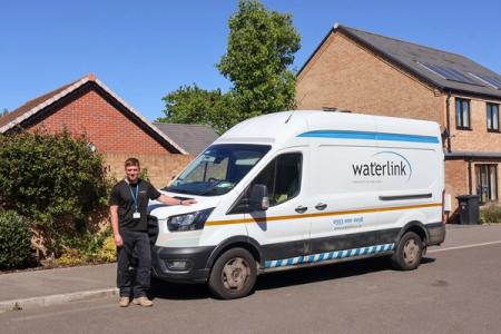A Waterlink technician is stood next to a Waterlink branded van.