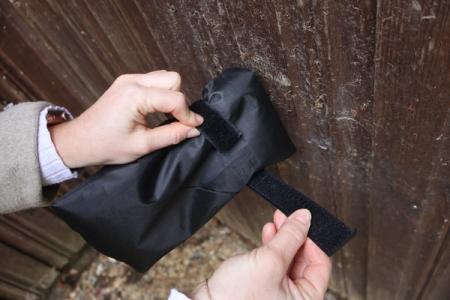 A woman's hand is wrapping a black tap jacket around an external tap.