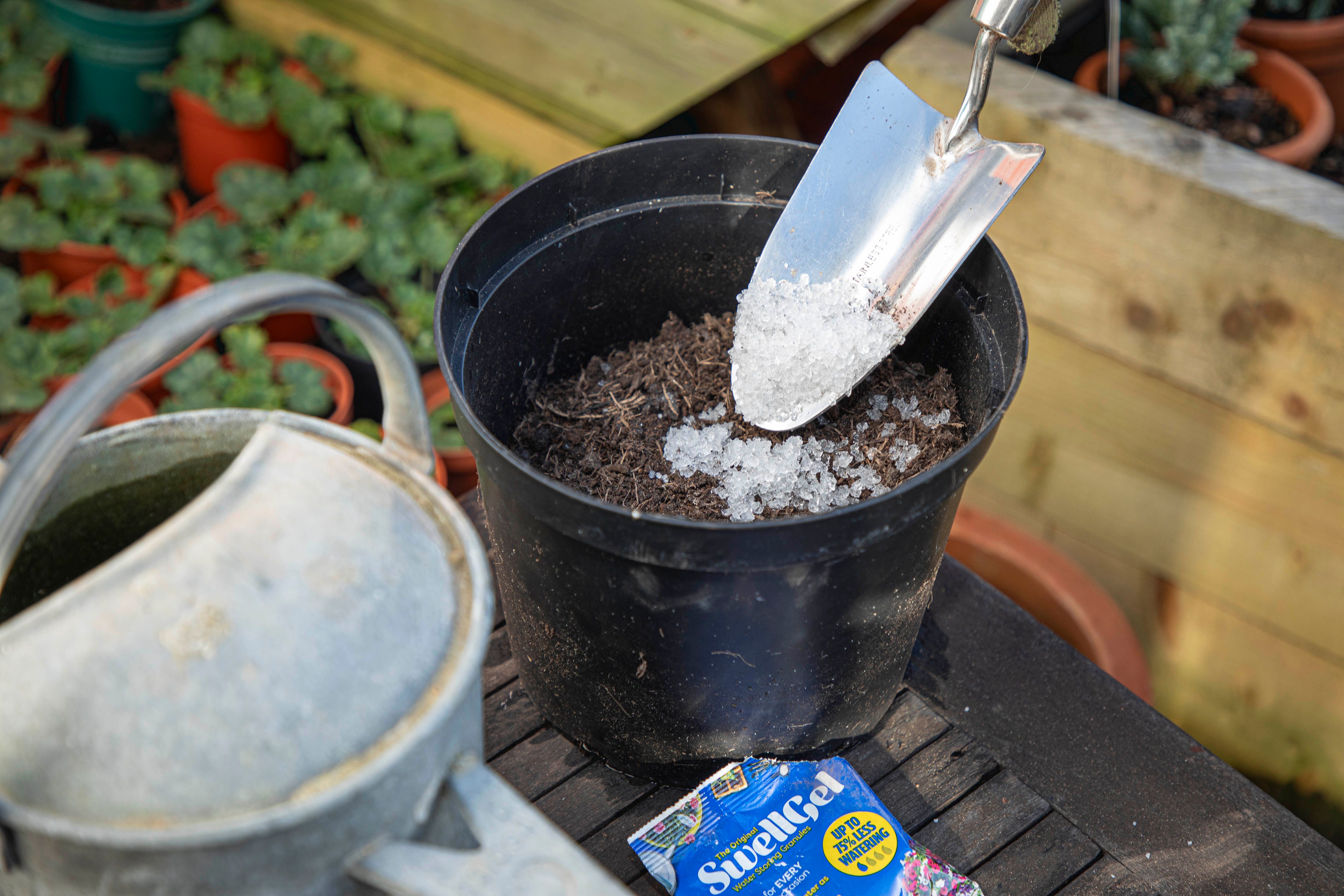 A person planting a flower pot using a Swell Gel pouch