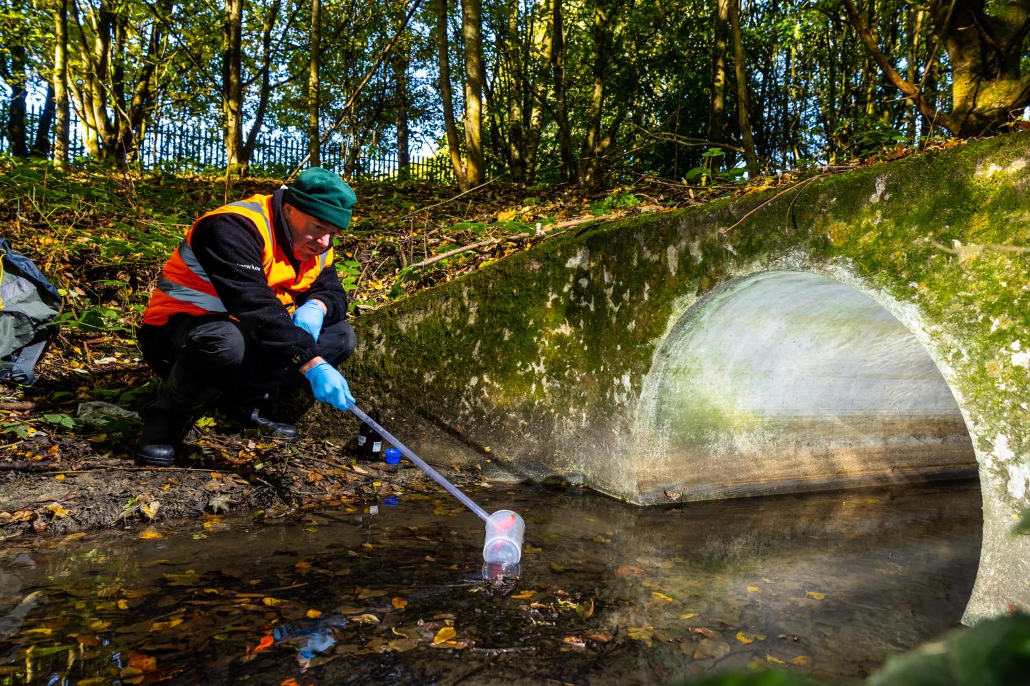 Man sampling water from stream 