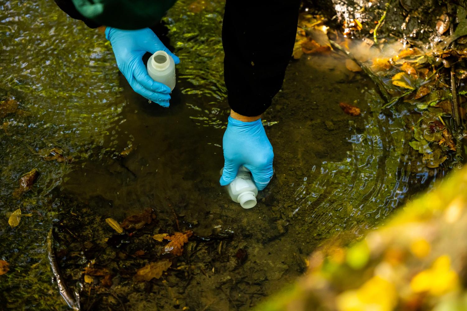 A south east water employee taking a sample from a river