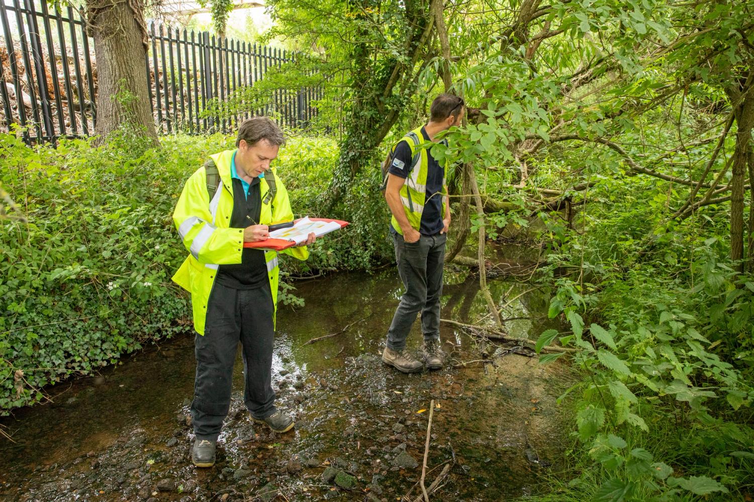Two South East Water employees assessing the River Darent