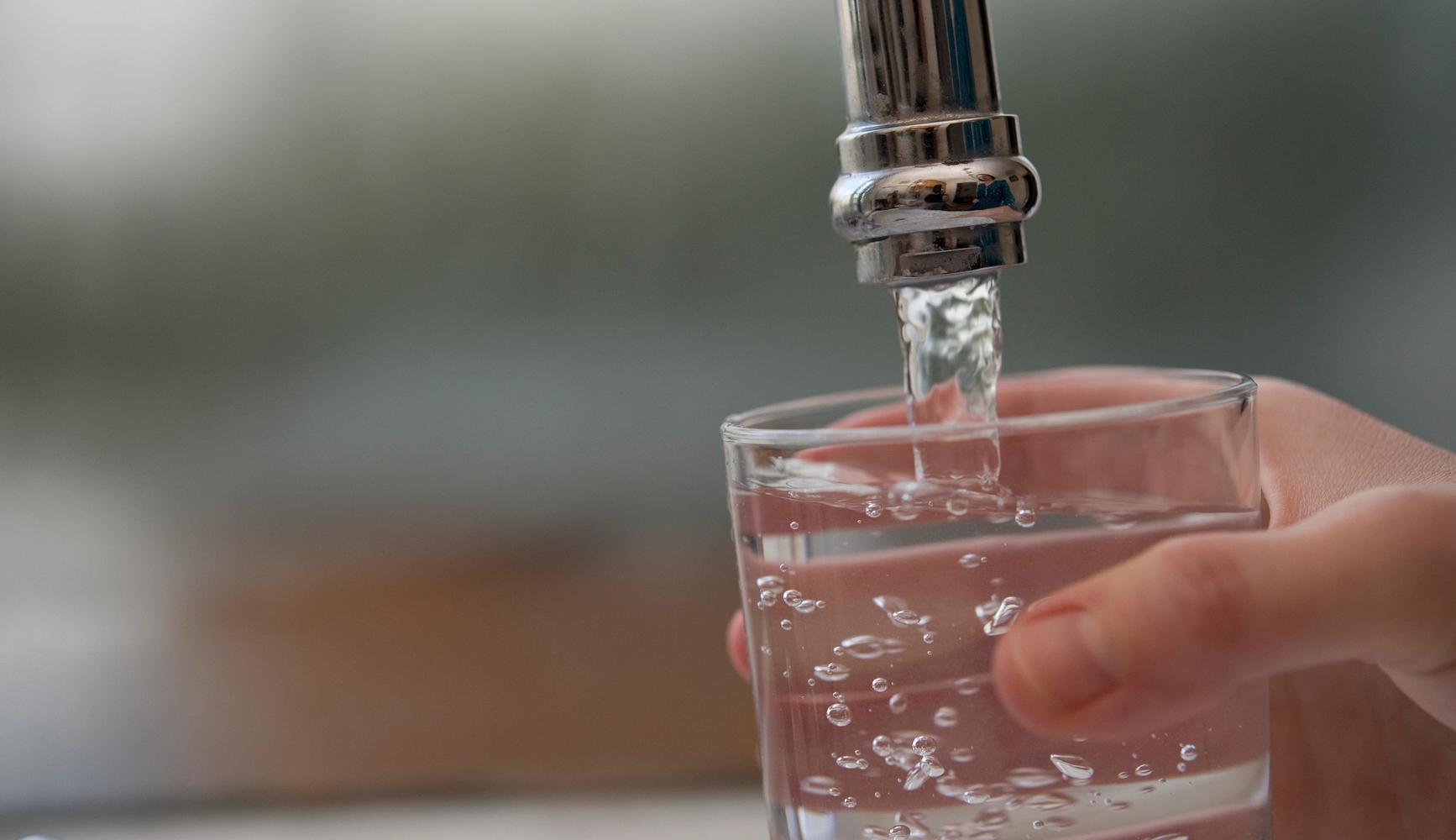 Image shows a glass being filled with water from a tap