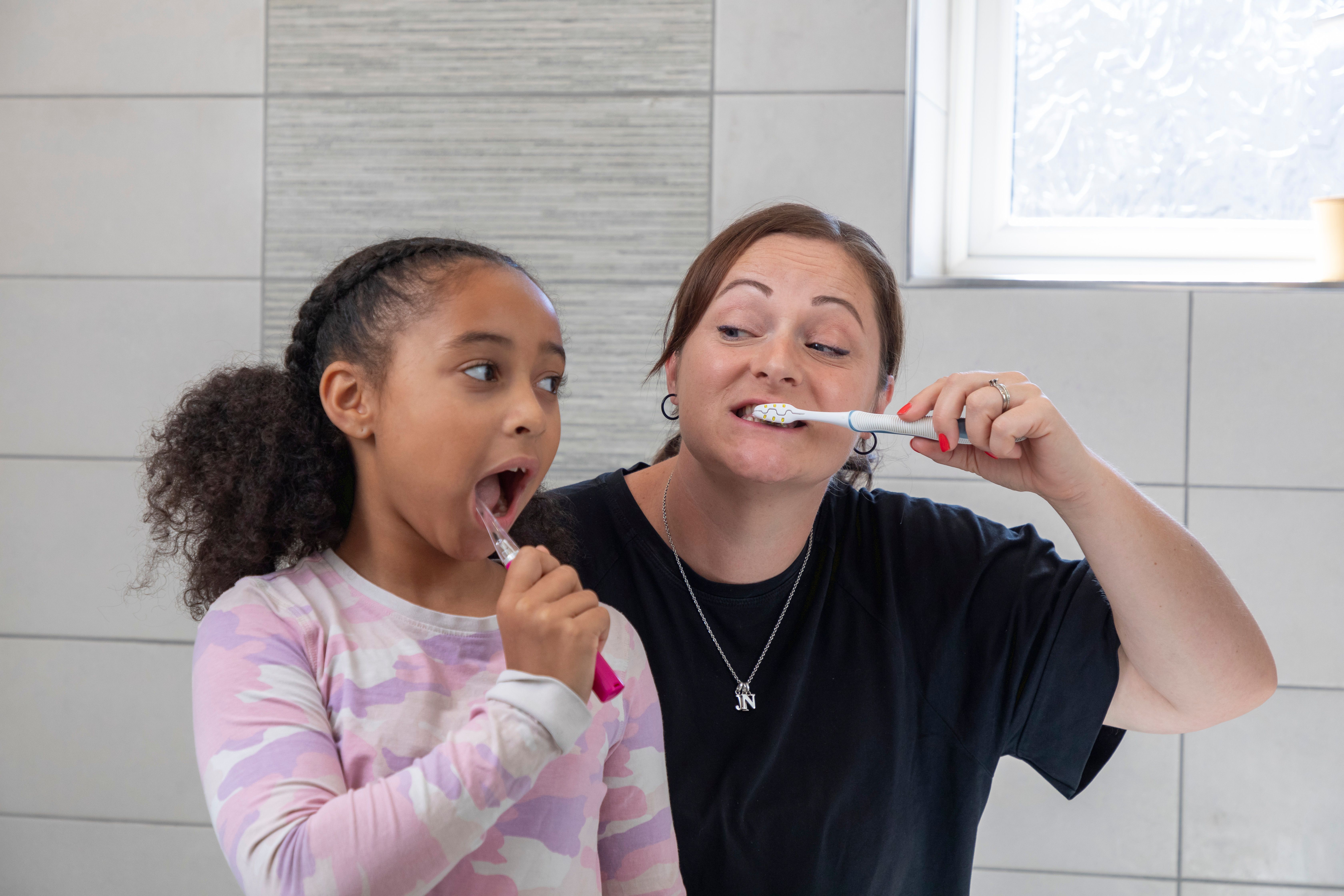 Mum and daughter brushing their teeth 