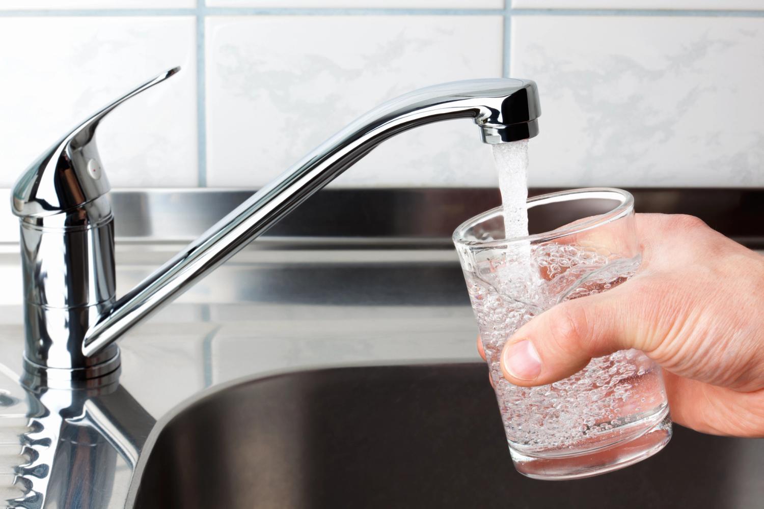 Photo of someone filling a small glass with tap water. Image sourced from shutterstock.
