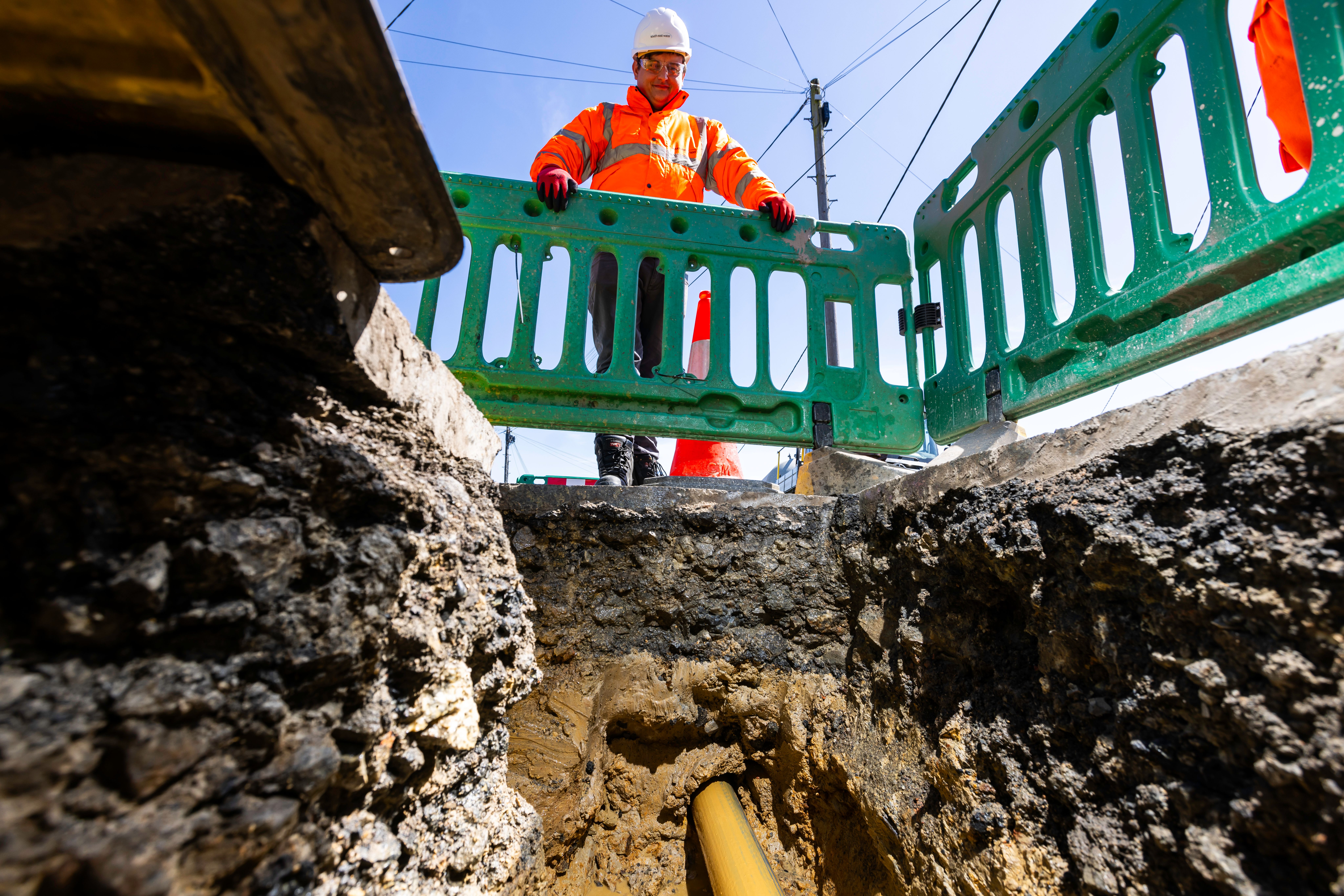 A technician in protective clothing overseeing the drilling of a new pipeline