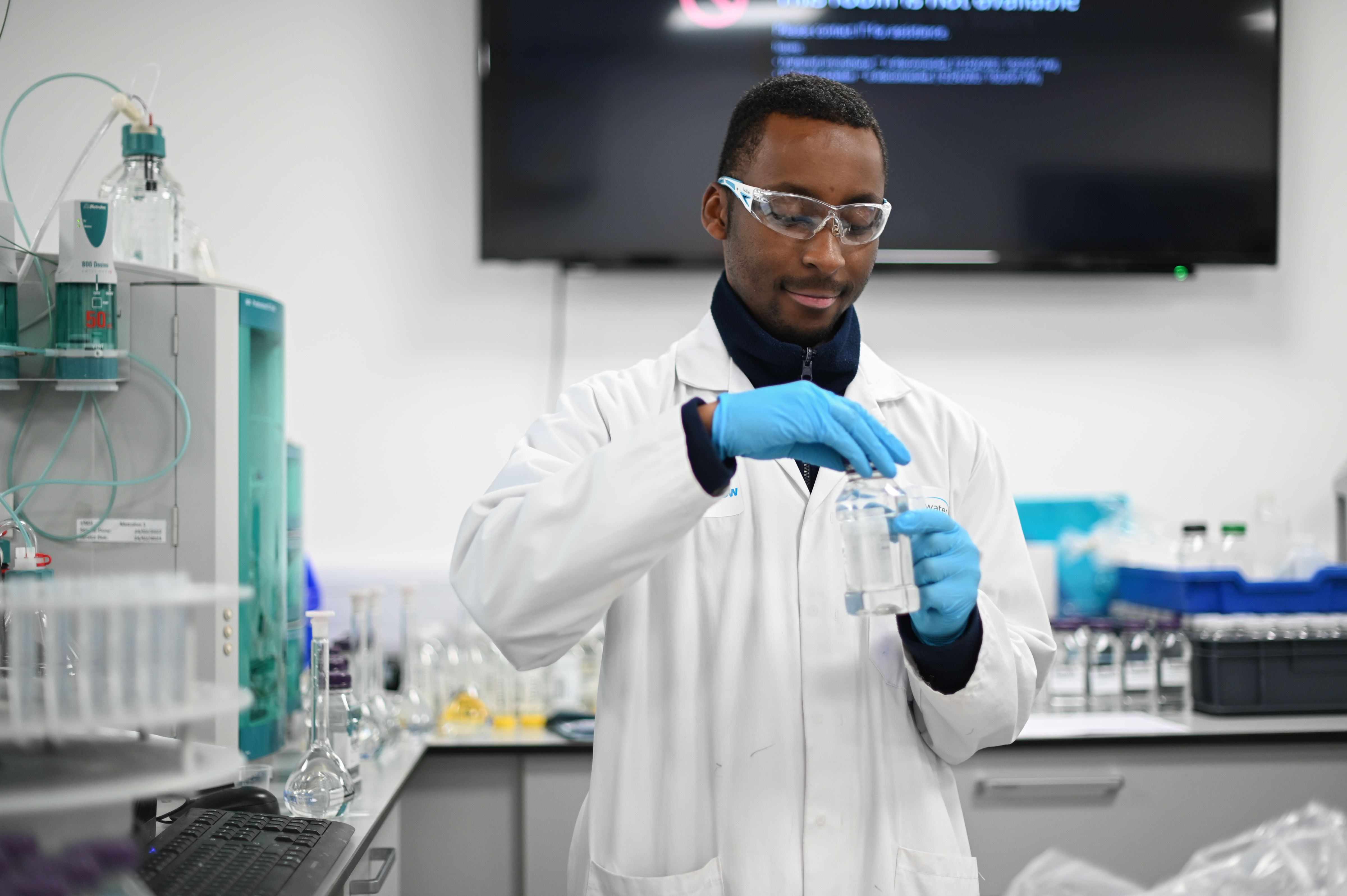 Scientist wearing blue gloves sampling water