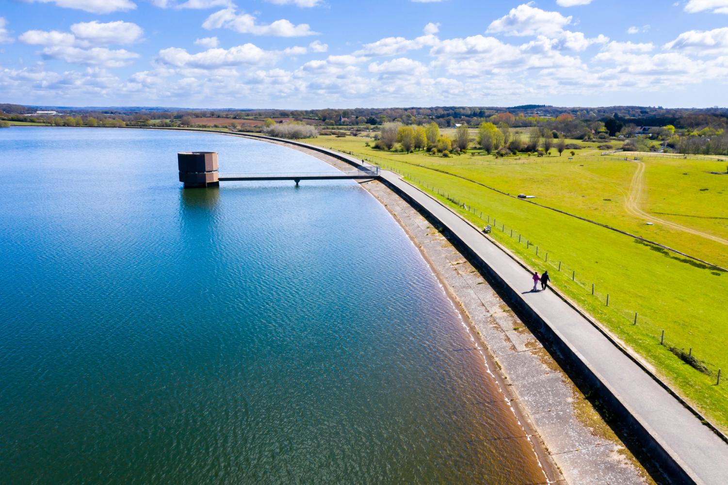 Two people walking around South East Water's reservoir in Arlington