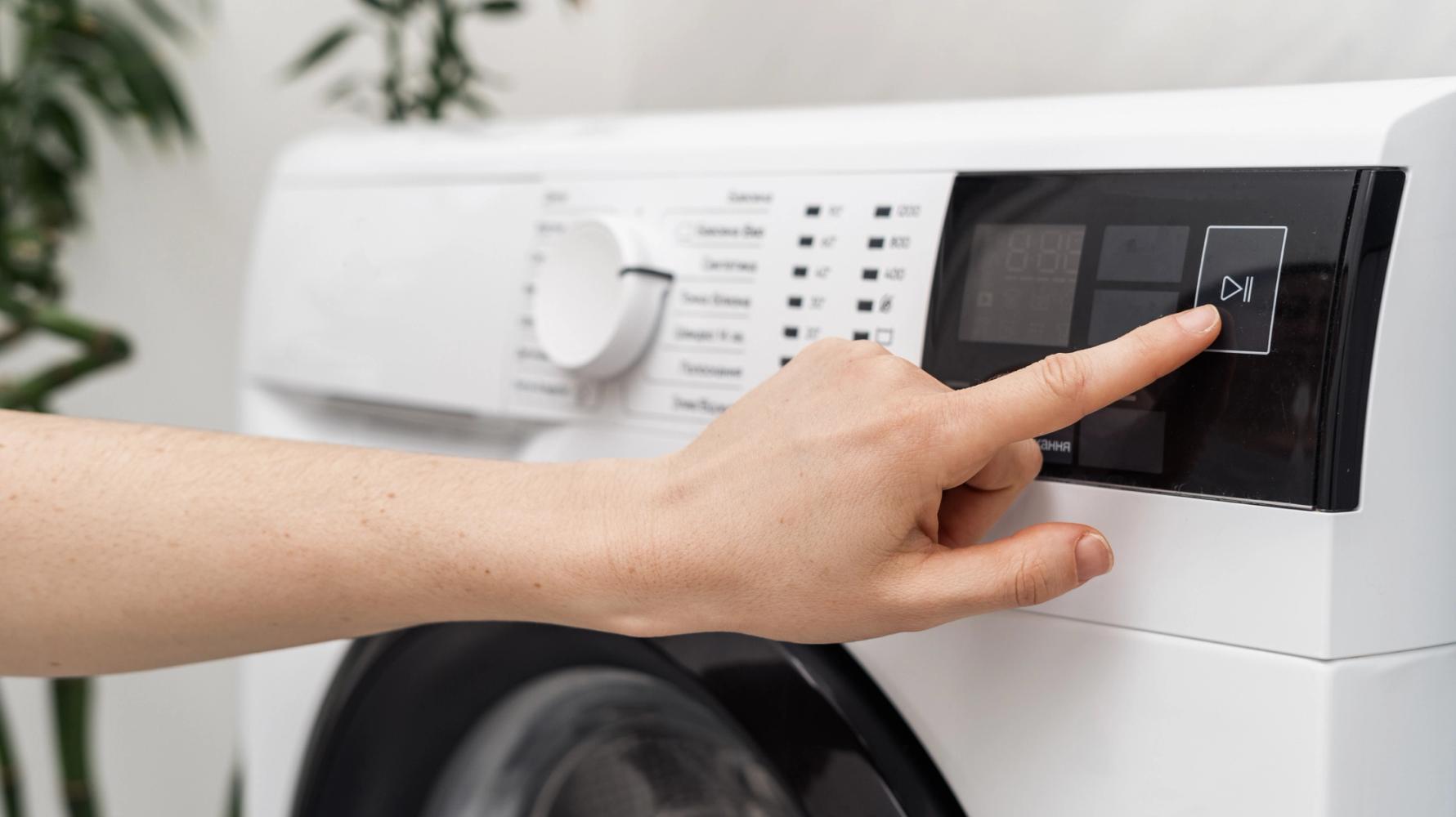 Photo of a person turning on a washing machine 