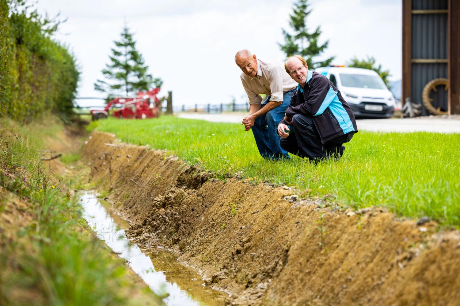 South East Water staff members working with a farmer on a field