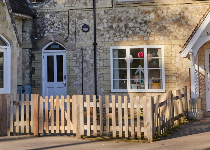 An image of the current outdoor space at Binsted School. The wooden lockers would go within the fence to the left of the front door.