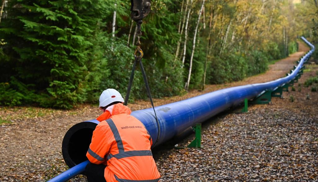 A South East Water employee inspects a pipe