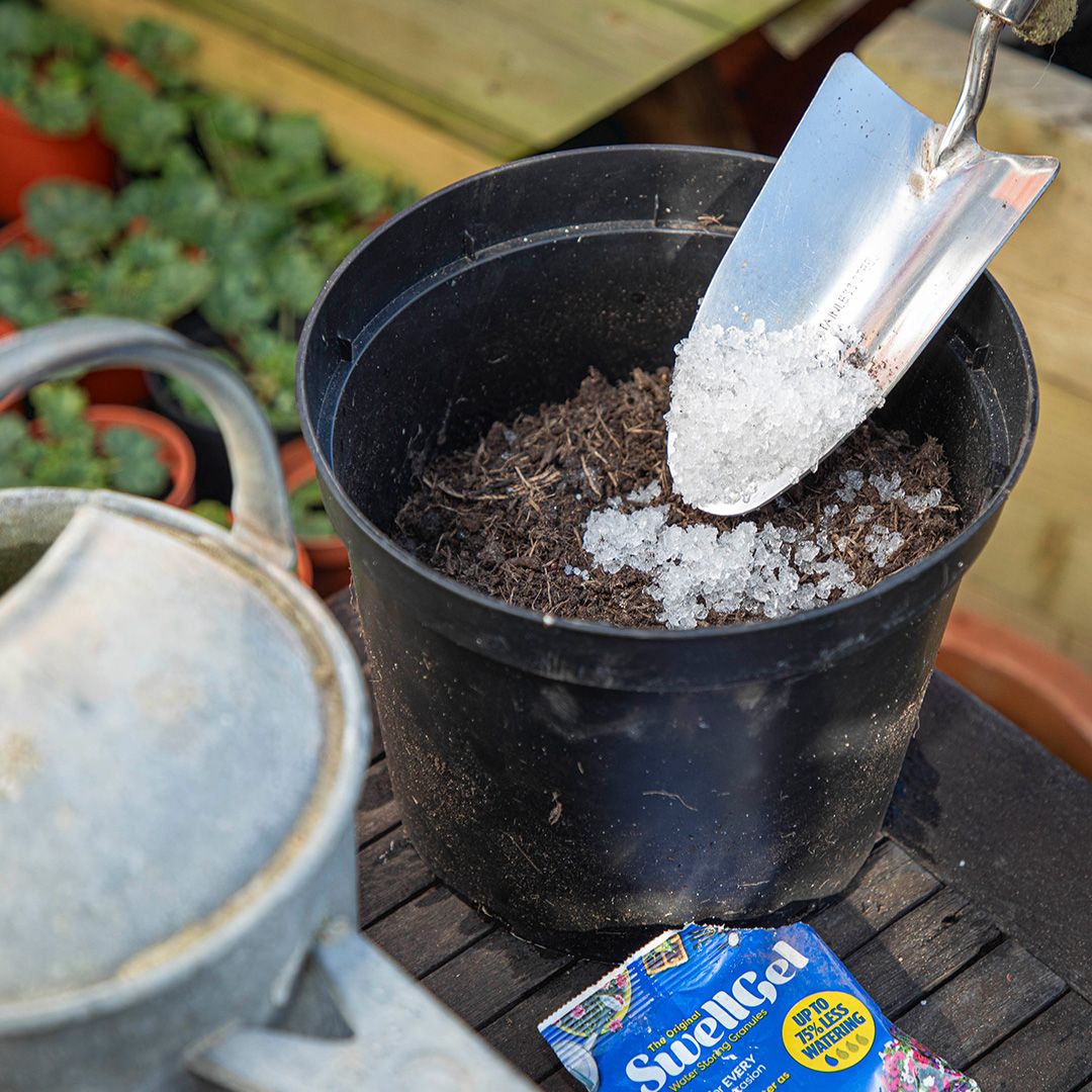 A person planting a flower pot using a Swell Gel pouch