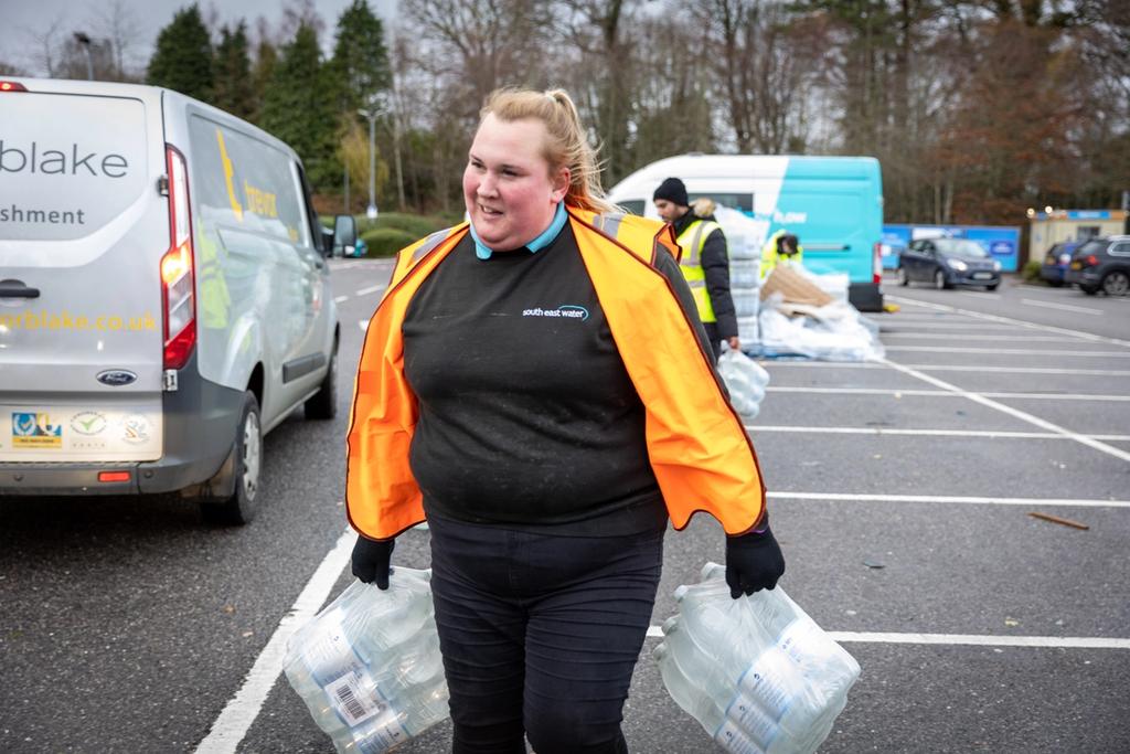 South East Water staff member handing out a pack of bottled water 