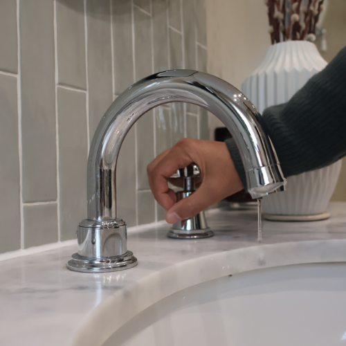 Image of a person turning the tap off.