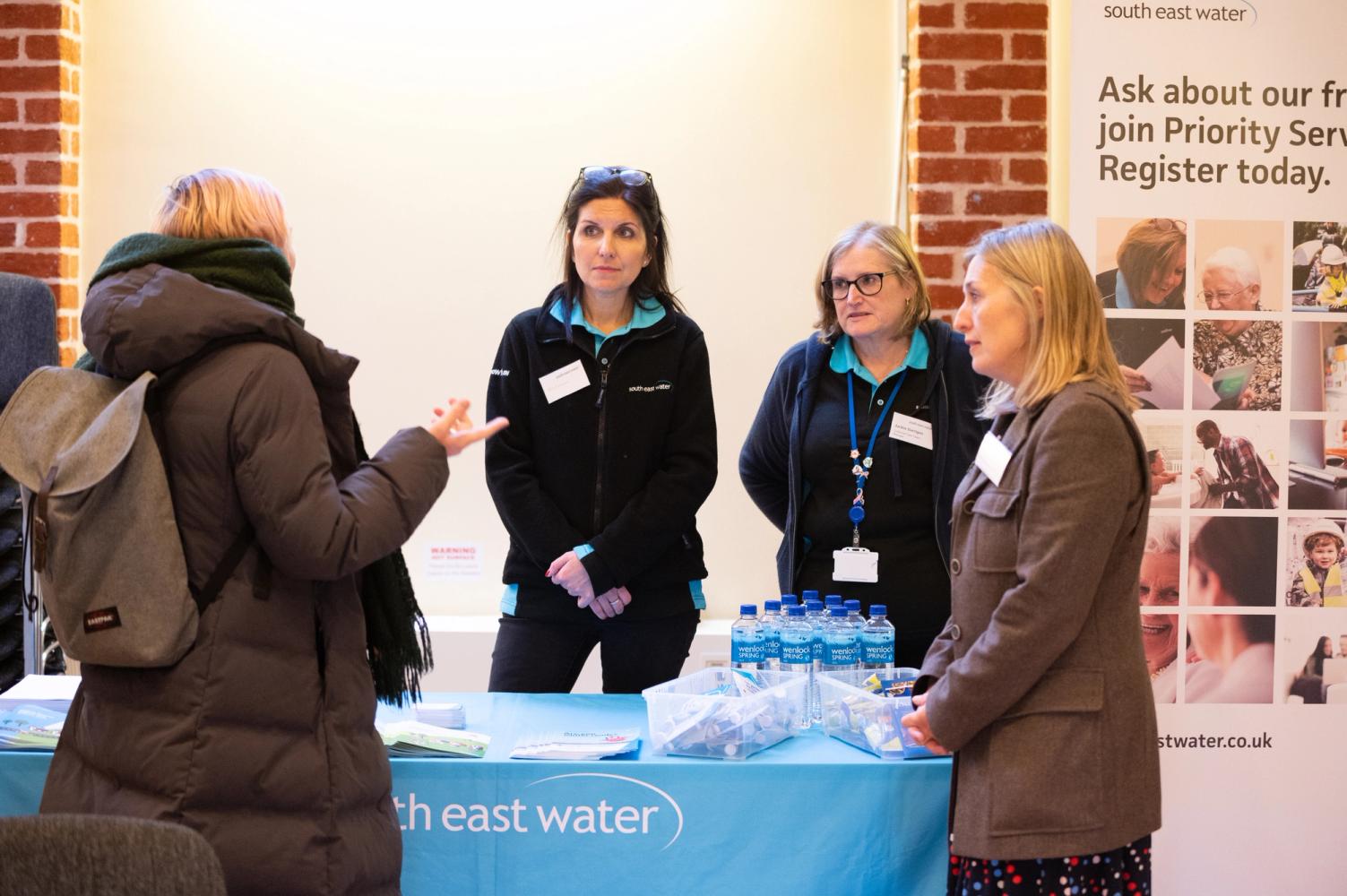 Photo of two South East Water employees stood chatting to members of the public at a drop in session