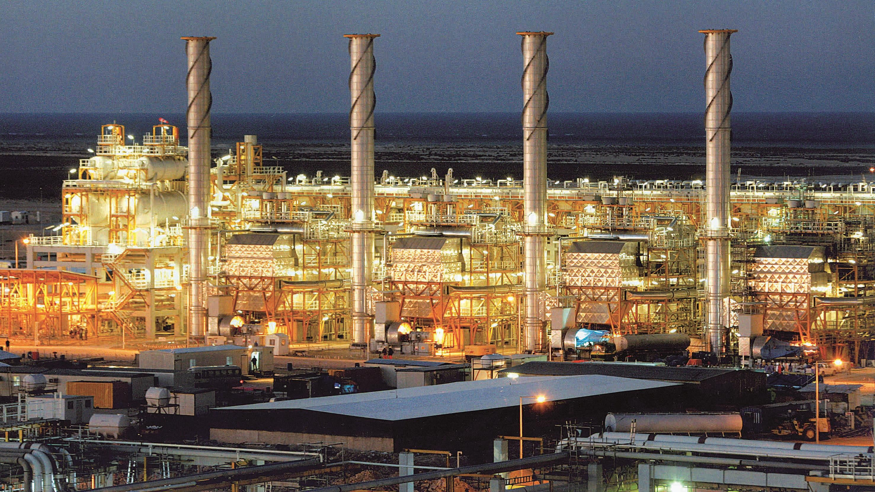 Energy professionals discussing LNG and industrial solutions at a Qatar energy exhibition.