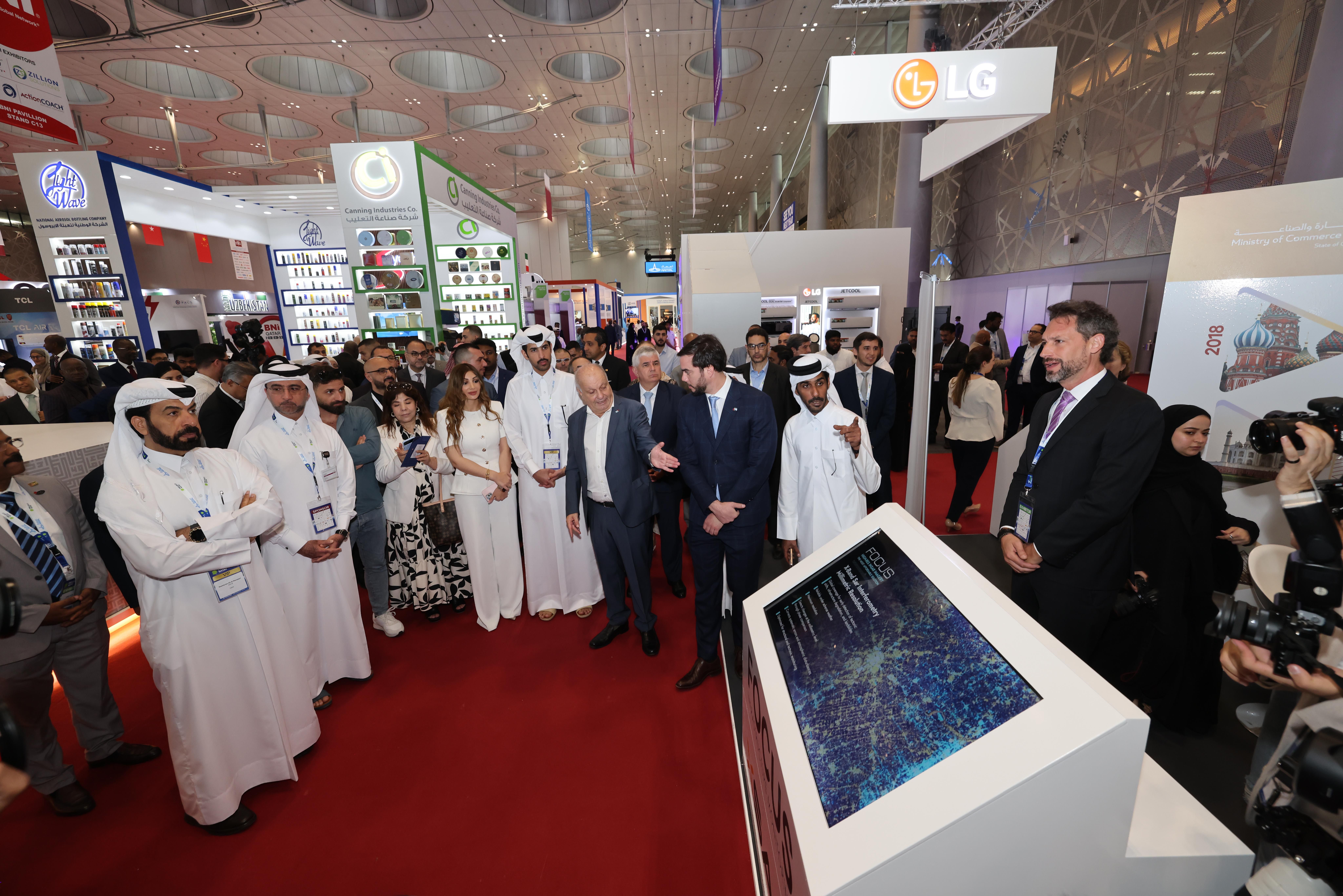Business professionals networking during a trade show in Qatar.