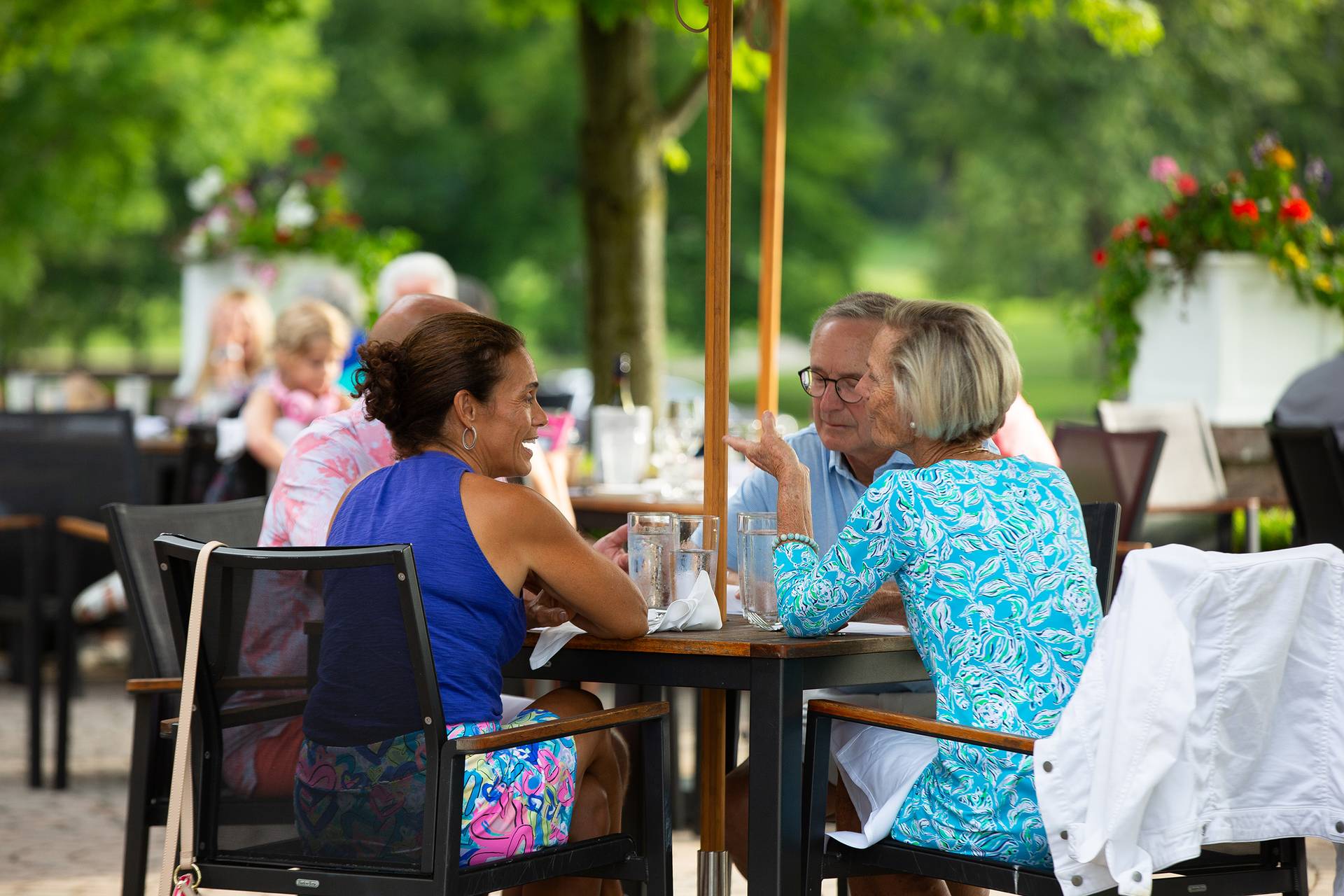 A group of people chatting and enjoying a meal on the Ross Patio