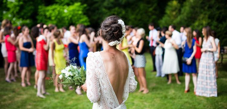 a marrier stands in front of a large group of wedding guests.