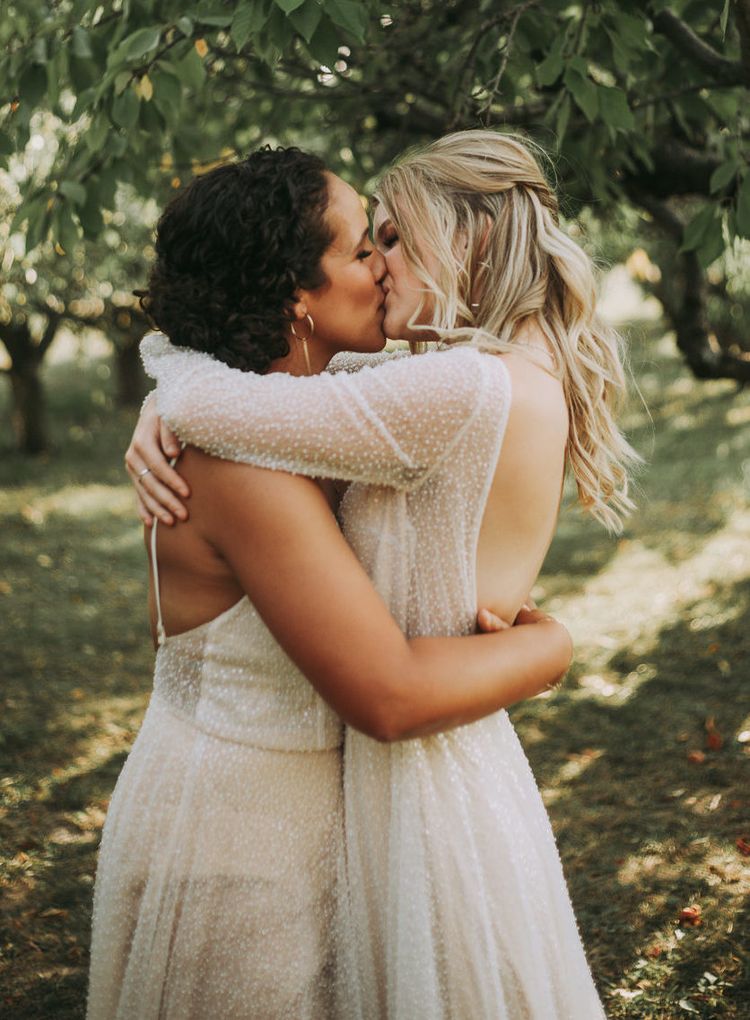 Two same sex brides share a kiss.