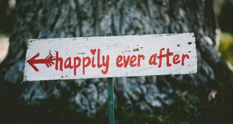 a wooden sign that reads "happily ever after"