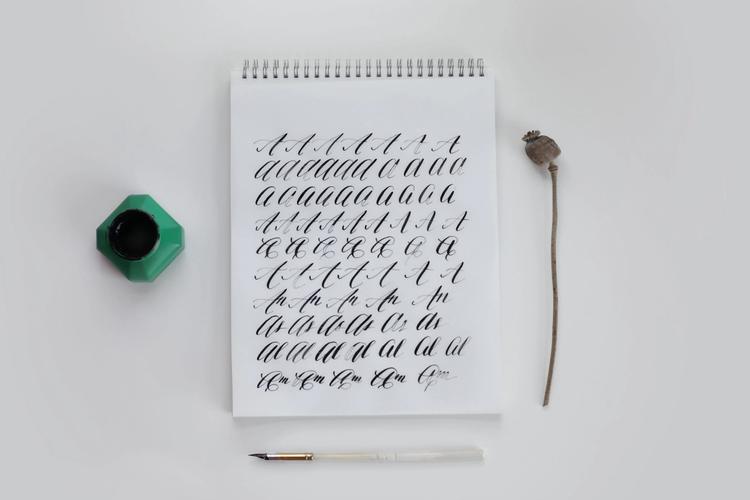 notebook with calligraphy drills: lowercase and uppercase cursive lettering.