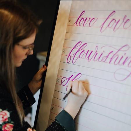 Calligraphy instructor does a live calligraphy demonstration for her students.