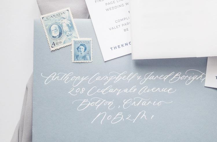 Dusty blue envelope with white address calligraphy