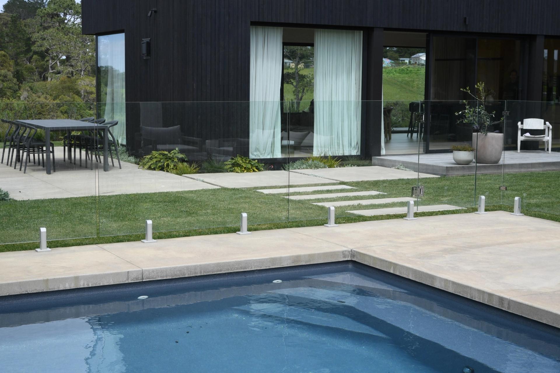 Honed concrete pool surround and pavers on an architectural Auckland home
