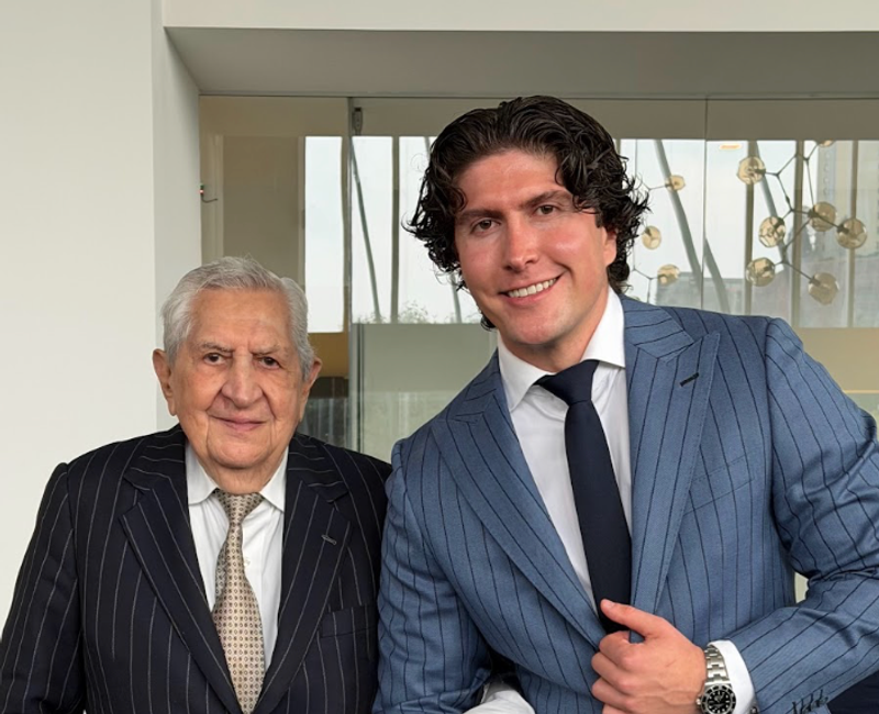 Mike y su abuelo Alberto con traje, sonrientes