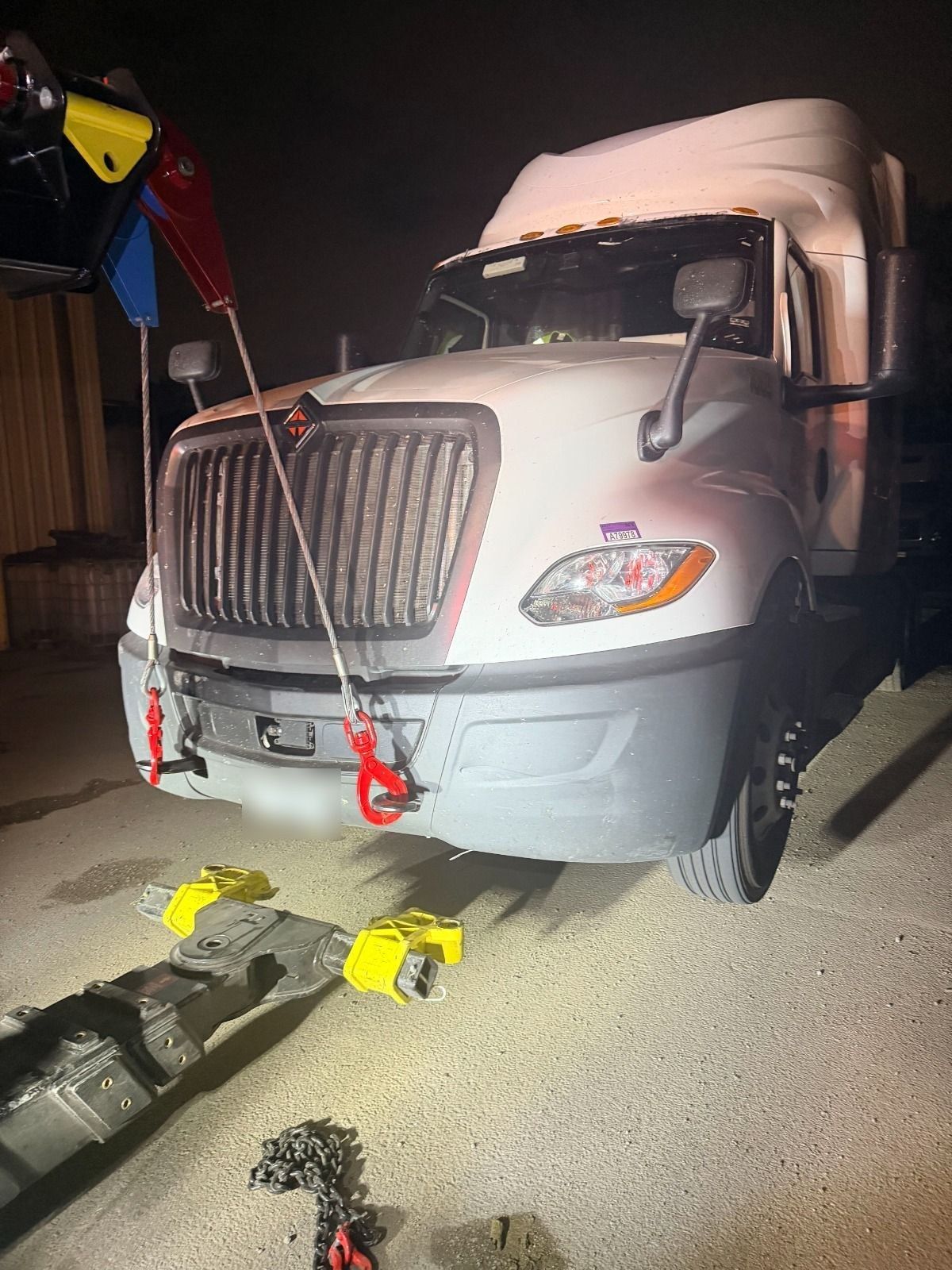 Semi truck rigged with recovery cables and shackles at night