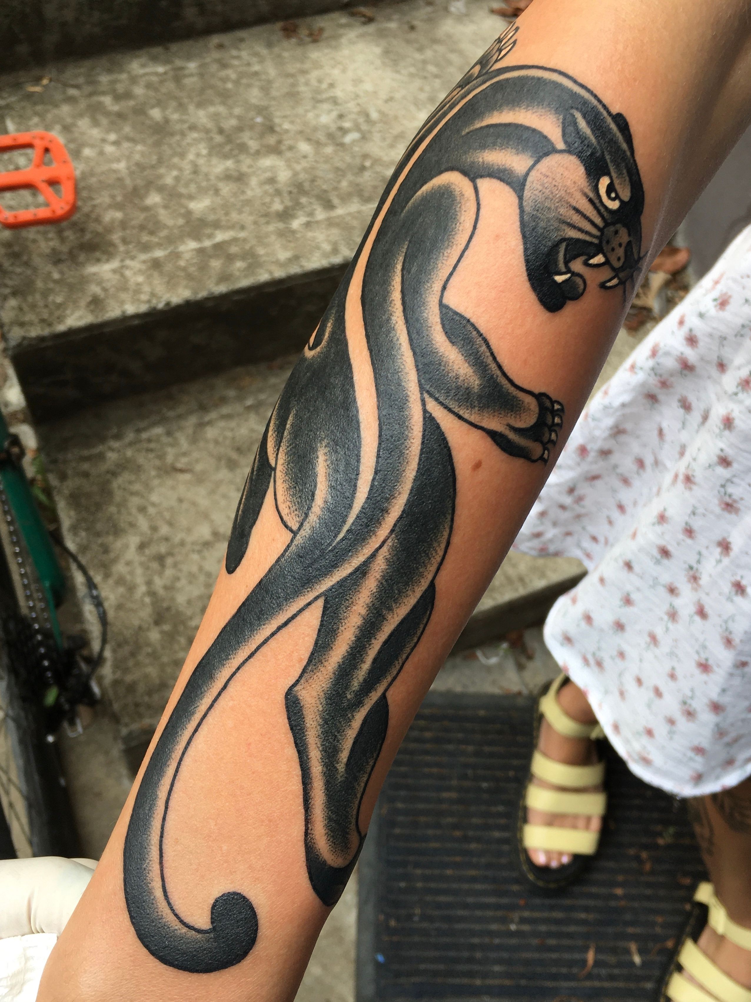 Galactic panther tattoo on the left inner forearm.