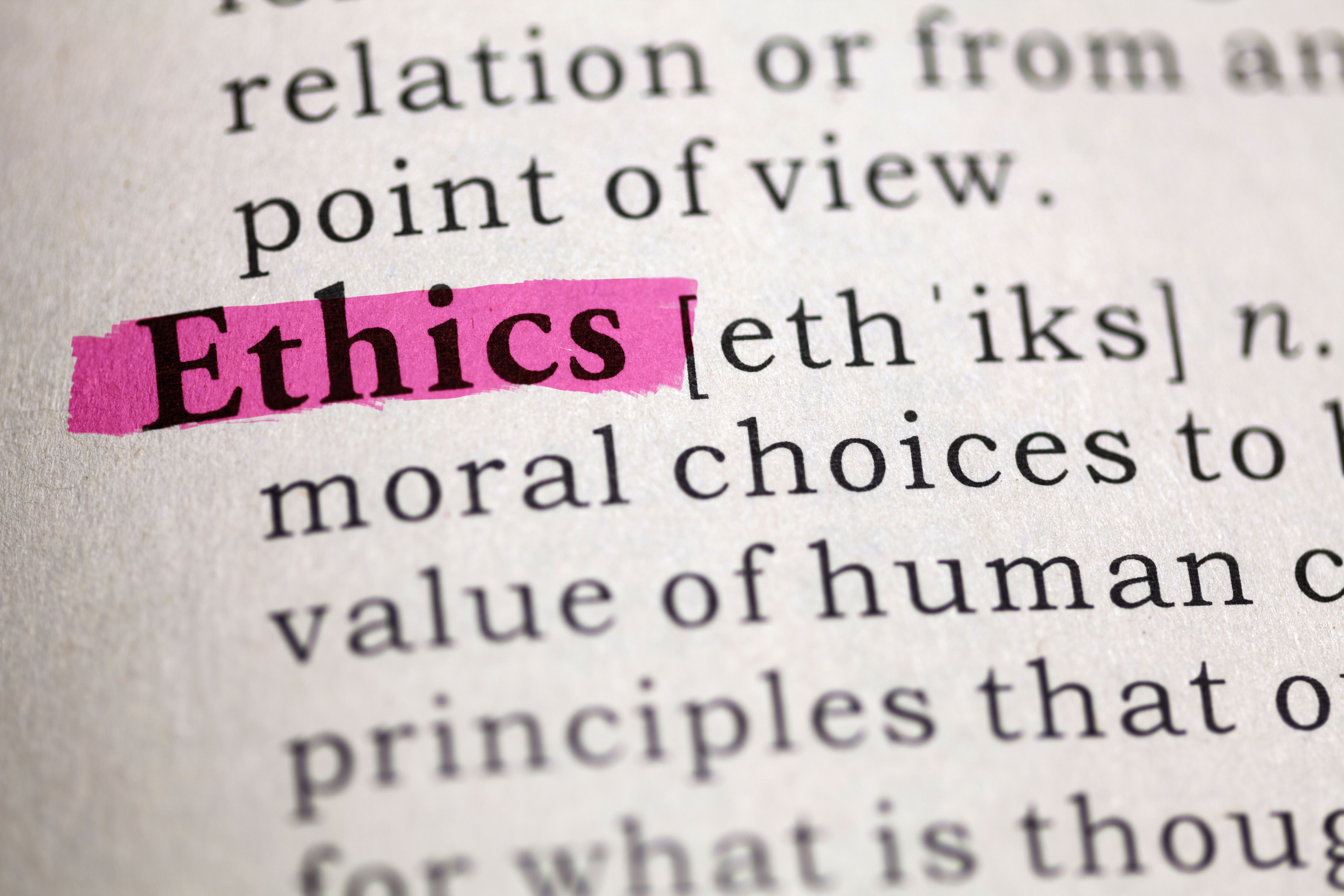 Close-up of a dictionary page with the word “Ethics” highlighted in pink marker, beside its phonetic spelling and definition about moral choices and principles.