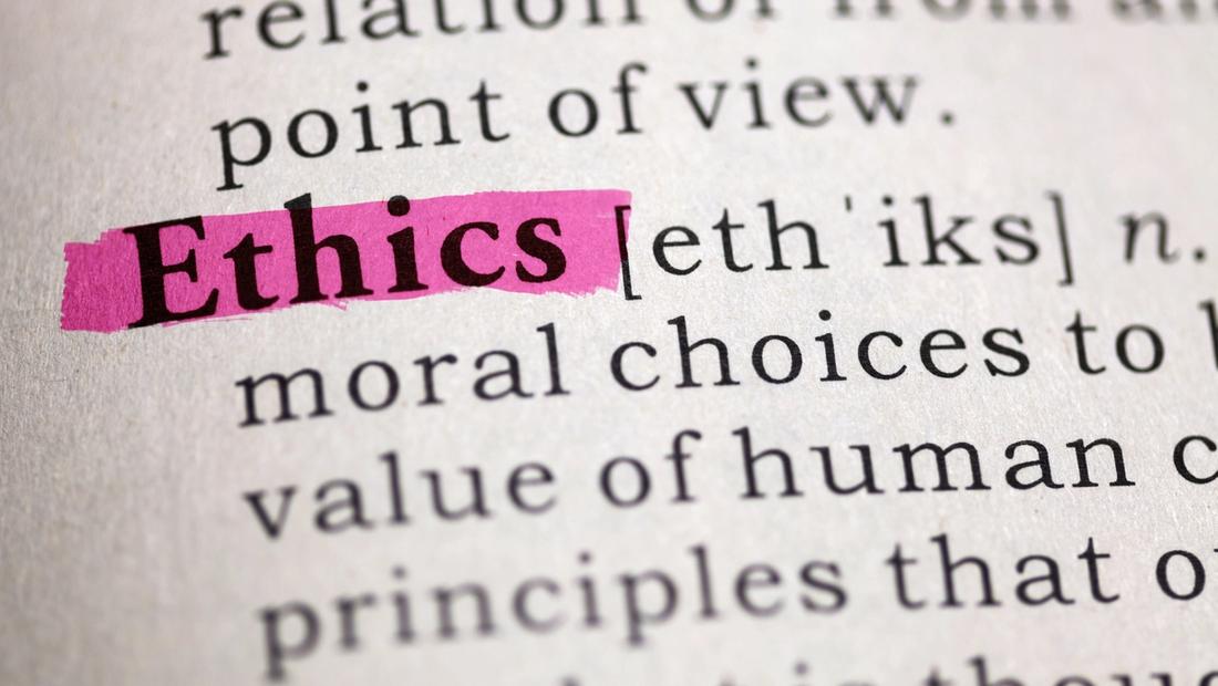Close-up of a dictionary page with the word “Ethics” highlighted in pink marker, beside its phonetic spelling and definition about moral choices and principles.
