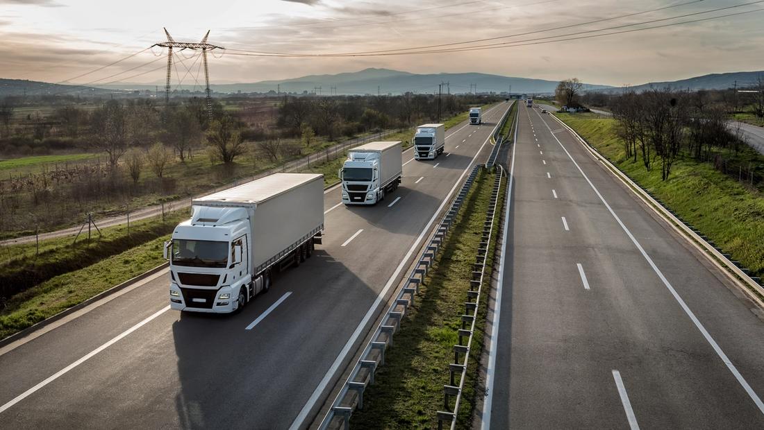 A commercial truck on a US interstate highway at dawn