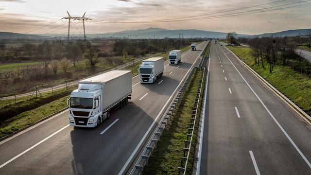 A commercial truck on a US interstate highway at dawn