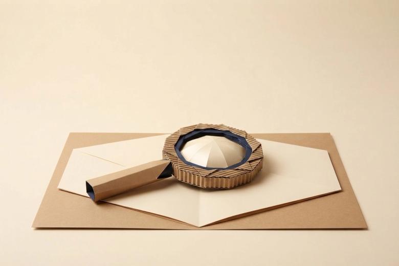 Paper-craft illustration of a folded paper clipboard on a kraft desk, holding a small cut-paper permit card beside a paper moving truck