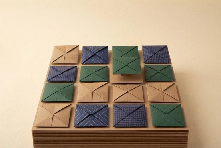 Paper-craft illustration of twelve small folded-paper squares in a grid, one raised slightly above the rest