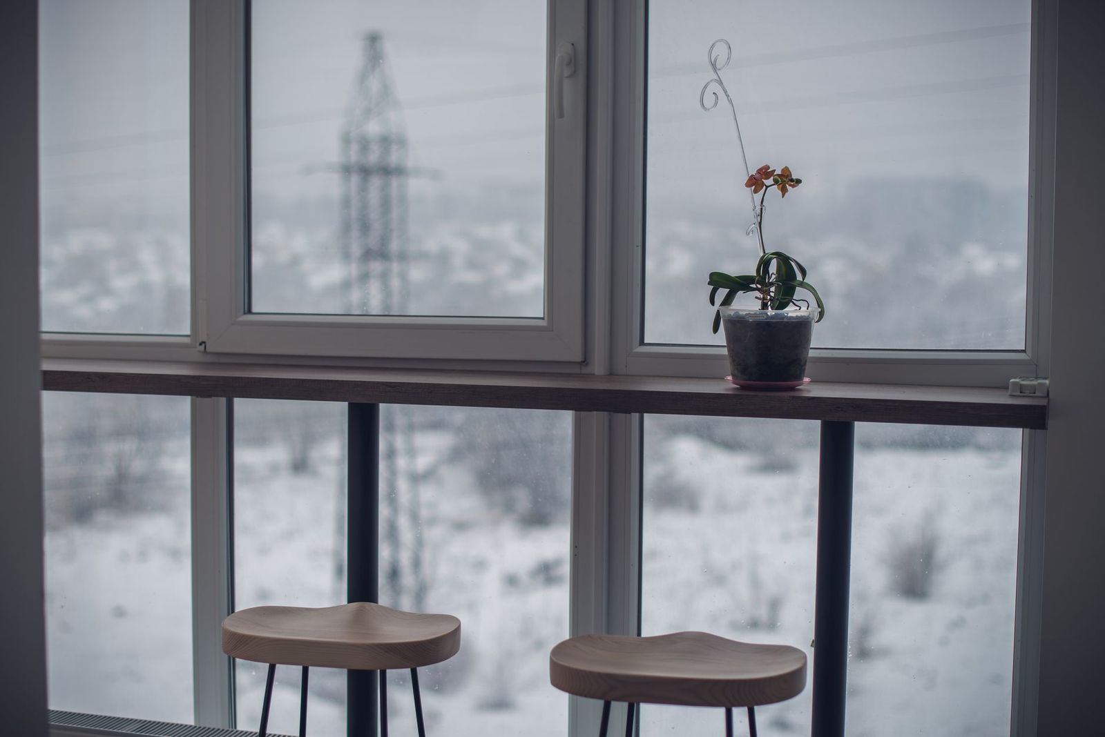 Fenêtre d'appartement donnant sur un paysage enneigé en hiver