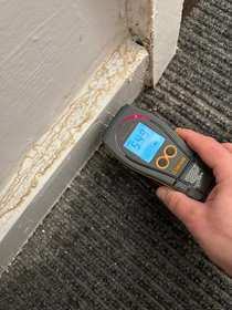 Moisture meter reading to hallway skirting board
