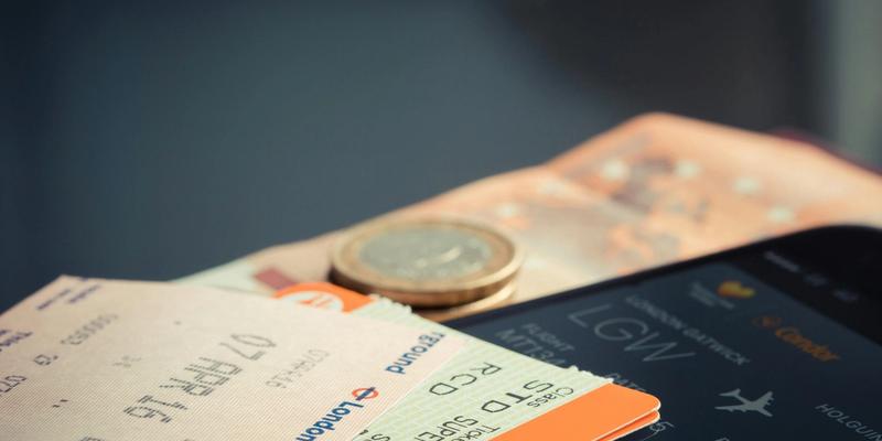 Zugtickets, Bordkarte auf dem Smartphone, Münze und Geldschein als Belege einer Dienstreise