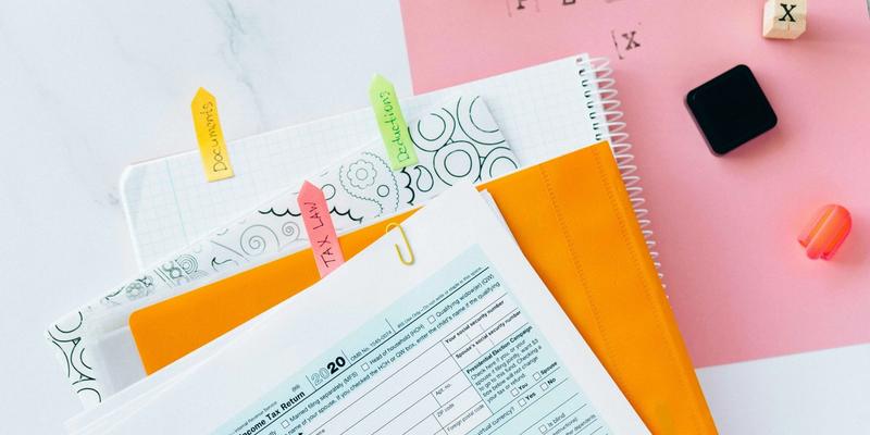 Steuerformulare und Notizblöcke mit Klebezetteln auf einem Schreibtisch
