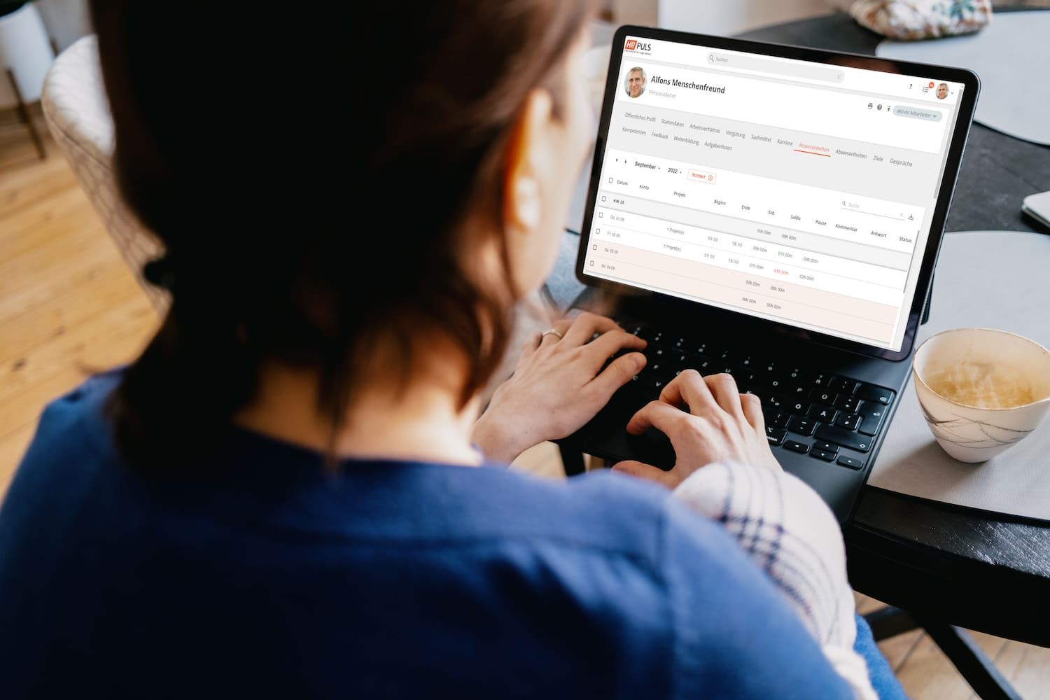 Mitarbeiterin arbeitet am Tablet mit HR Puls und prüft ihre Anwesenheitszeiten