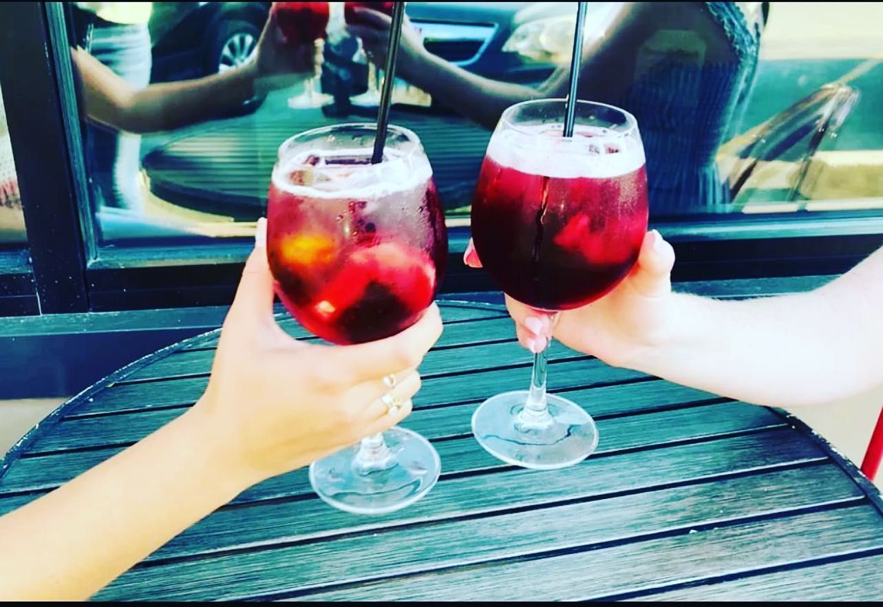 Friends raising sangria glasses by the window